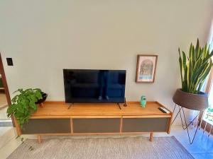 a flat screen tv sitting on top of a entertainment center at Edifício Barão Filippi in Águas de Lindoia