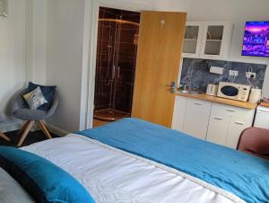 a bedroom with a bed and a kitchen with a microwave at Precise Homes in Wolverhampton