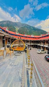 a large building with benches and a building with mountains at Kaka G Hotel Utror Valley in Utrot