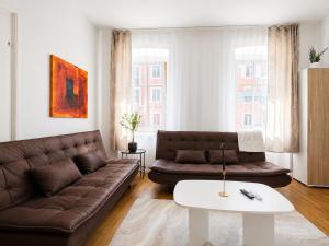 a living room with a couch and a table at KAISERLICH WOHNEN zentral und am Fluss in Bad Ischl