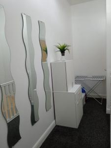 a room with a wall with three paintings on it at Precise Homes in Wolverhampton