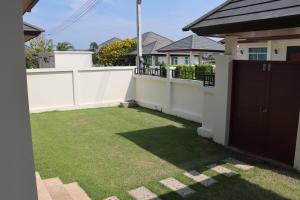 a small backyard with a white fence and grass at Hua Hin, Pool Villa, Nice Breeze 7 in Ban Bo Fai (1)