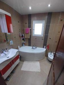 a bathroom with a tub and a sink and a toilet at Yamina's Holiday in Raoued