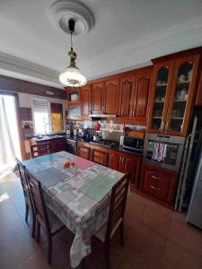 a kitchen with a table with chairs and a kitchen with at Yamina's Holiday in Raoued +6 photos