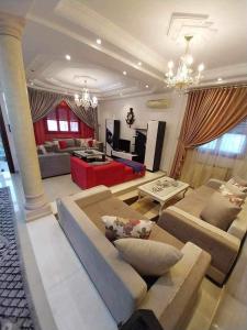 a large living room with couches and a red couch at Yamina's Holiday in Raoued