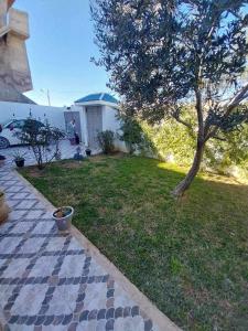 a yard with a tree and a house at Yamina's Holiday in Raoued