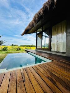 a house with a wooden deck and a swimming pool at Ranakeliya Lodge - Yala in Yala