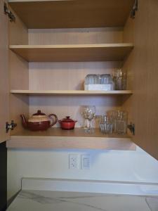 a kitchen shelves with bowls and glasses on them at Private Guest Suite Sleeps 4 in Riverview +1 photo