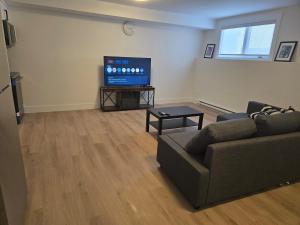 a living room with a couch and a flat screen tv at Private Guest Suite Sleeps 4 in Riverview