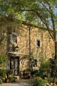 an old stone building with plants in front of it at Can Portell by 123ole, B&B - Casa Rural in Sant Andreu del Terri