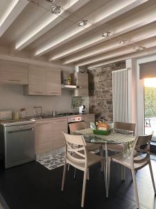 a kitchen with a table and chairs and a kitchen with a counter at Borgo&Lago Home in Castro