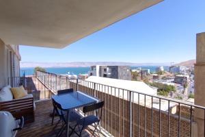 a balcony with a table and chairs and a view of the ocean at Migdalor apartments Tiberias in Tiberias
