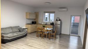 a living room with a couch and a table and a kitchen at Luca House in Remetea Mare