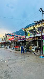 a person with an umbrella standing in front of a building at Kaka G Hotel Utror Valley in Utrot