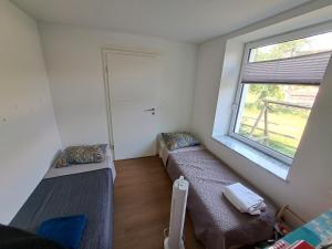 a small room with two beds and a window at Casa Stein am Rhein inkl Pool in Stein am Rhein