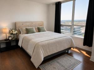 a bedroom with a large bed with a large window at SimplyBnB in Vaughan