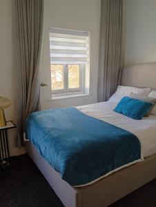 a bedroom with a bed with a blue blanket on it at Precise Homes in Wolverhampton