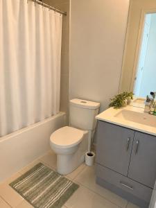 a bathroom with a toilet and a sink and a shower curtain at SimplyBnB in Vaughan