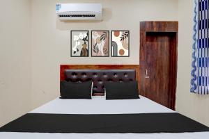 a bedroom with a bed with a black and white bedspread at Hotel O Star Light in Rohtak