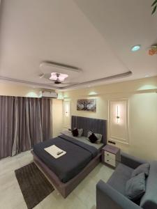 a bedroom with a bed and a couch at Aureva stays Omaxe Hazratganj in Nalmatha +5 photos