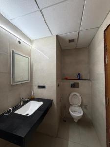 a bathroom with a sink and a toilet at Aureva stays Omaxe Hazratganj in Nalmatha