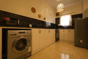 a kitchen with a washing machine and a refrigerator at calming valley in Luxor