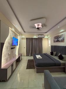 a bedroom with a bed and a tv in it at Aureva stays Omaxe Hazratganj in Nalmatha