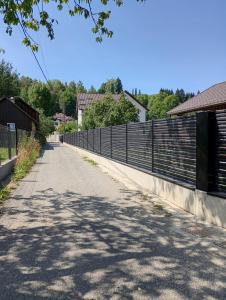 an empty road with a fence on the side at Apartament Adelina Borsa in Borşa