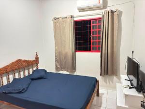 a bedroom with a blue bed and a window at Pousada Marialva in Barreiras +3 photos