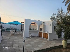 a kitchen and an outdoor patio with an umbrella at Appartement Touta écologique familial in Ḩawmat al Badawīyīn