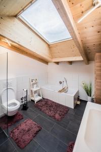a bathroom with a tub and a toilet and a sink at Tyrolhaus in Grinzens +12 photos