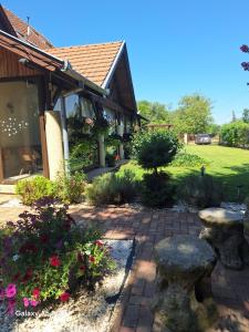 a garden with flowers and a brick patio at Neon2 - Vendégház in Orosháza +38 photos