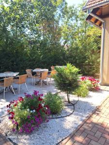 a patio with tables and chairs and flowers at Neon2 - Vendégház in Orosháza