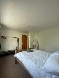 a bedroom with a white bed and a mirror at Penrhyn View in Bangor