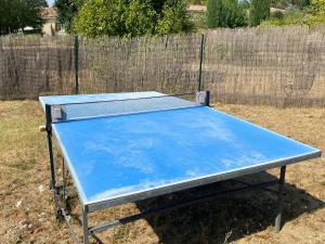 a blue ping pong table sitting in the grass at Les OLIVETTES CLIMATISÉES d'UZES à Garrigues Sainte Eulalie in Garrigues-et-Sainte-Eulalie
