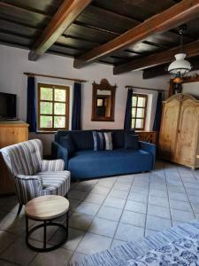 a living room with a blue couch and chairs at Zora Vendégház in Tihany