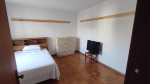 a bedroom with a bed and a tv in it at Sobrado Jardim Itália in Itapetininga
