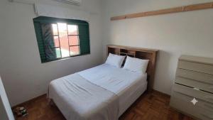 a small bedroom with a bed and a window at Sobrado Jardim Itália in Itapetininga