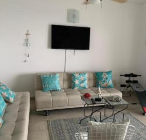 ein Wohnzimmer mit Sofa und Flachbildfernseher in der Unterkunft Torres del mar in Same