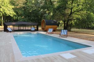 a swimming pool with two chairs and a gazebo at Château de Praslins in Nogent-sur-Vernisson