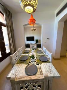 a dining room with a table and a chandelier at Sabina 2BD with pool and lagoon view in Hurghada