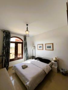 a bedroom with a large bed and a window at Sabina 2BD with pool and lagoon view in Hurghada