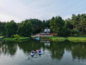 two canoes in the water in front of a house at Szept Wody Kaszuby in Lubiana