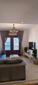 a living room with a couch and a tv at Sabina 2BD with pool and lagoon view in Hurghada
