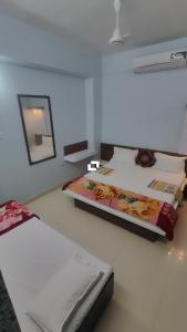 a bedroom with two beds and a mirror at Hotel adiraj palace exclusive in Ahmadnagar