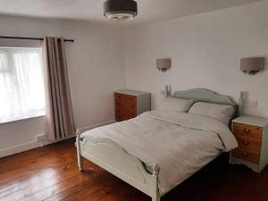 a bedroom with a white bed and a window at Cosy Bala House in Bala