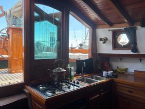 a kitchen with a stove and a sink and a window at Argovia Dutch Barge in Brightlingsea