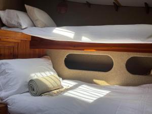 two bunk beds on a boat with a towel on them at Argovia Dutch Barge in Brightlingsea