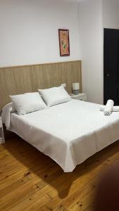 a bedroom with a large white bed with a wooden floor at Hotel Termas Camino Real in Ourense
