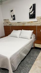 a bedroom with a white bed and a table at Hotel Termas Camino Real in Ourense